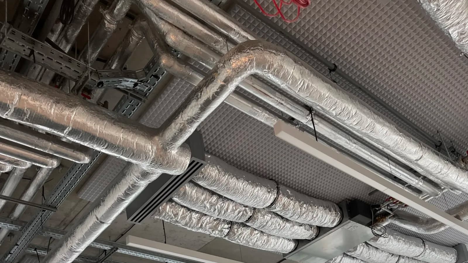 Réseaux de gaines de ventilation isolées installés sous un plafond technique
